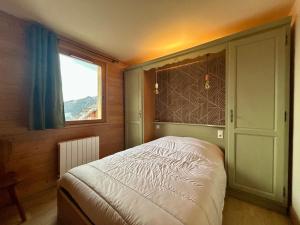 a bedroom with a bed in a room with a window at Alpine Mood - Vue - Balcon - Parking in Uvernet