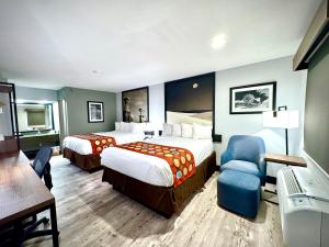 a hotel room with two beds and a chair at SureStay Plus by Best Western Cannon A.F.B. in Clovis +64 photos