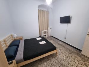 a bedroom with a bed and a flat screen tv at Uddin House in Genoa