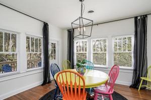 a dining room with a table and chairs and windows at Colorful waterside home in Bradenton