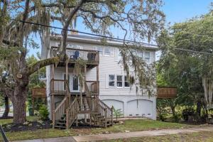 a white house with a tree in front of it at Colorful waterside home in Bradenton