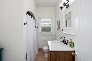 a white bathroom with a sink and a toilet at Colorful waterside home in Bradenton +33 photos