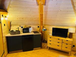 a kitchen with a counter with a microwave and a tv at La Clé de L Insolite in Hudiviller