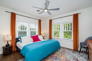 a bedroom with a bed and a ceiling fan at Colorful waterside home in Bradenton