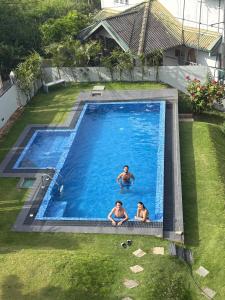 two people are swimming in a swimming pool at Kandy krush Hotel in Kandy