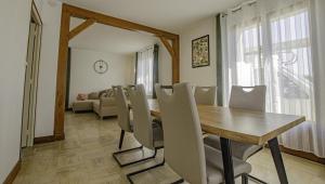 a dining room with a wooden table and chairs at Maison des 3 lacs in Chavanges