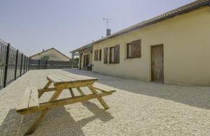 a wooden picnic table sitting outside of a building at Maison des 3 lacs in Chavanges