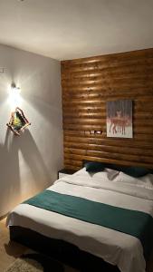 a bedroom with a large bed with a wooden headboard at Pensiunea Lavinia Daniel in Borşa