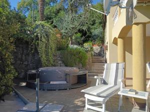 a patio with a hot tub and a chair and stairs at Apartman Lori in Lovran +40 photos