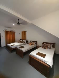 a bedroom with two beds and a staircase at Hiri Dudes Villa in Dickwella