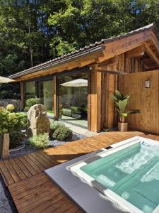 ein Whirlpool auf einer Holzterrasse mit einem Gebäude in der Unterkunft Residence Alpi - Private Spa & Living in Grainau