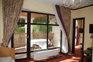 a room with a large window with a dog sitting on a balcony at Chalet Zolota Pidkova&River 1 in Slavske +95 photos