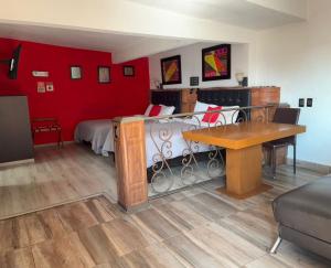 a room with a bedroom with a bed and a table at Suites Aldama in Toluca