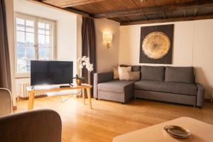 a living room with a couch and a tv at BnB SchlafSchloss in Sumiswald