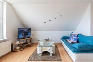 a living room with a blue couch and a tv at Ferienwohnung Sterntaler in Goldbeck