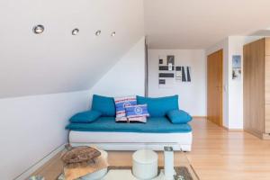 a room with a couch with blue pillows at Ferienwohnung Sterntaler in Goldbeck