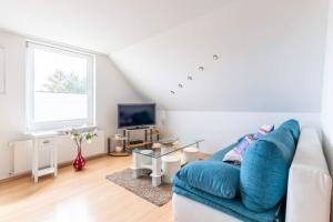 a living room with a blue couch and a tv at Ferienwohnung Sterntaler in Goldbeck