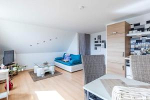 a living room with a blue couch and a table at Ferienwohnung Sterntaler in Goldbeck