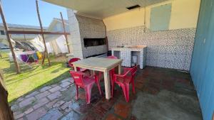 a table and chairs in a patio with a fireplace at Quartos Beira Mar ARROIO TEIXEIRA in Capão da Canoa