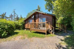 a wooden cabin with a porch and a deck at La Conner Camping Resort Cabin 7 in La Conner