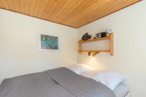 a bedroom with a bed and a shelf on the wall at Ferienhaus am Strand 92a - Bade- & Saunawelt täglich inklusive in Baabe +7 photos