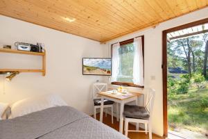 a bedroom with a bed and a table and a window at Ferienhaus am Strand 92a - Bade- & Saunawelt täglich inklusive in Baabe