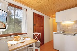 a kitchen with a small table and a window at Ferienhaus am Strand 92a - Bade- & Saunawelt täglich inklusive in Baabe