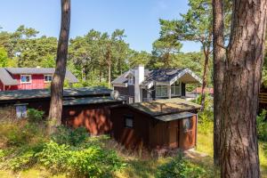 a house with a shed in the woods at Ferienhaus am Strand 92a - Bade- & Saunawelt täglich inklusive in Baabe