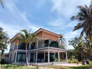 a house with palm trees in front of it at Pool Villa Romance in Sawi