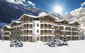 ein großes Gebäude im Schnee vor einem Berg in der Unterkunft Residenz Drachenstein Wildschönau in Niederau