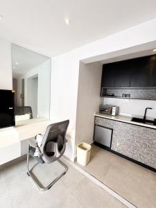a room with a chair and a table and a kitchen at MAISON 9 Apartments Surulere in Lagos