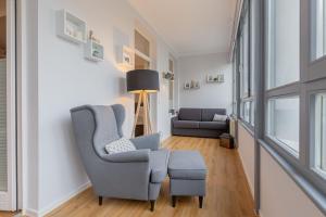 a living room with a blue chair and a stool at Villa Odin, Muschelsucher - Bade- & Saunawelt täglich inklusive in Ostseebad Sellin