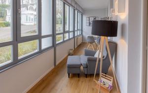 a living room with a blue chair and a lamp at Villa Odin, Muschelsucher - Bade- & Saunawelt täglich inklusive in Ostseebad Sellin