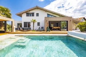 a house with a swimming pool in front of a house at La Petite Californie - Piscine in Anglet