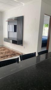 a room with a wall with a fireplace and a microwave at Casa aconchegante com piscina e garagem dupla in Búzios