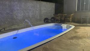 a bath tub with blue water in a room at Casa aconchegante com piscina e garagem dupla in Búzios