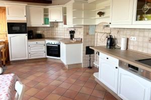 a kitchen with white cabinets and a tile floor at Wietblick in Ockholm
