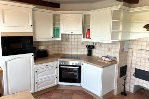 a white kitchen with white cabinets and appliances at Wietblick in Ockholm