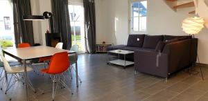 a living room with a couch and a table and chairs at Reethaus "Alinde" in Zierow