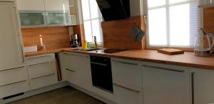 a kitchen with white cabinets and a sink and a stove at Reethaus "Alinde" in Zierow