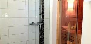 a bathroom with a shower with a glass door at Reethaus "Alinde" in Zierow +12 photos