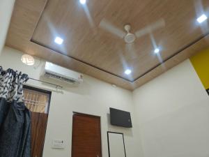 a living room with a ceiling fan and a tv at Hari Sharnam Residency in Mathura