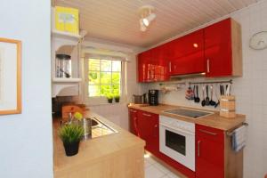 a kitchen with red cabinets and a counter top at Bungalow Nixe in Tarnewitz