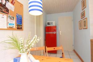 a room with a table and a red refrigerator at Bungalow Nixe in Tarnewitz