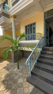 a house with a blue railing and stairs at Nsenou Tower in Yaoundé