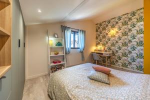 a small bedroom with a bed and a desk at La Petite Californie - Piscine in Anglet