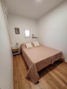 a bedroom with a bed in a white room at Gîte L'alcôve in Issendolus