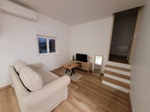 a living room with a white couch and a table at Gîte L'alcôve in Issendolus
