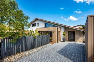 a home with a fence and a driveway at La Petite Californie - Piscine in Anglet