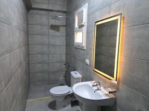 a bathroom with a sink and a toilet and a mirror at New Cairo Cozy Studio استديو فندقى بالتجمع in New cairo +19 photos